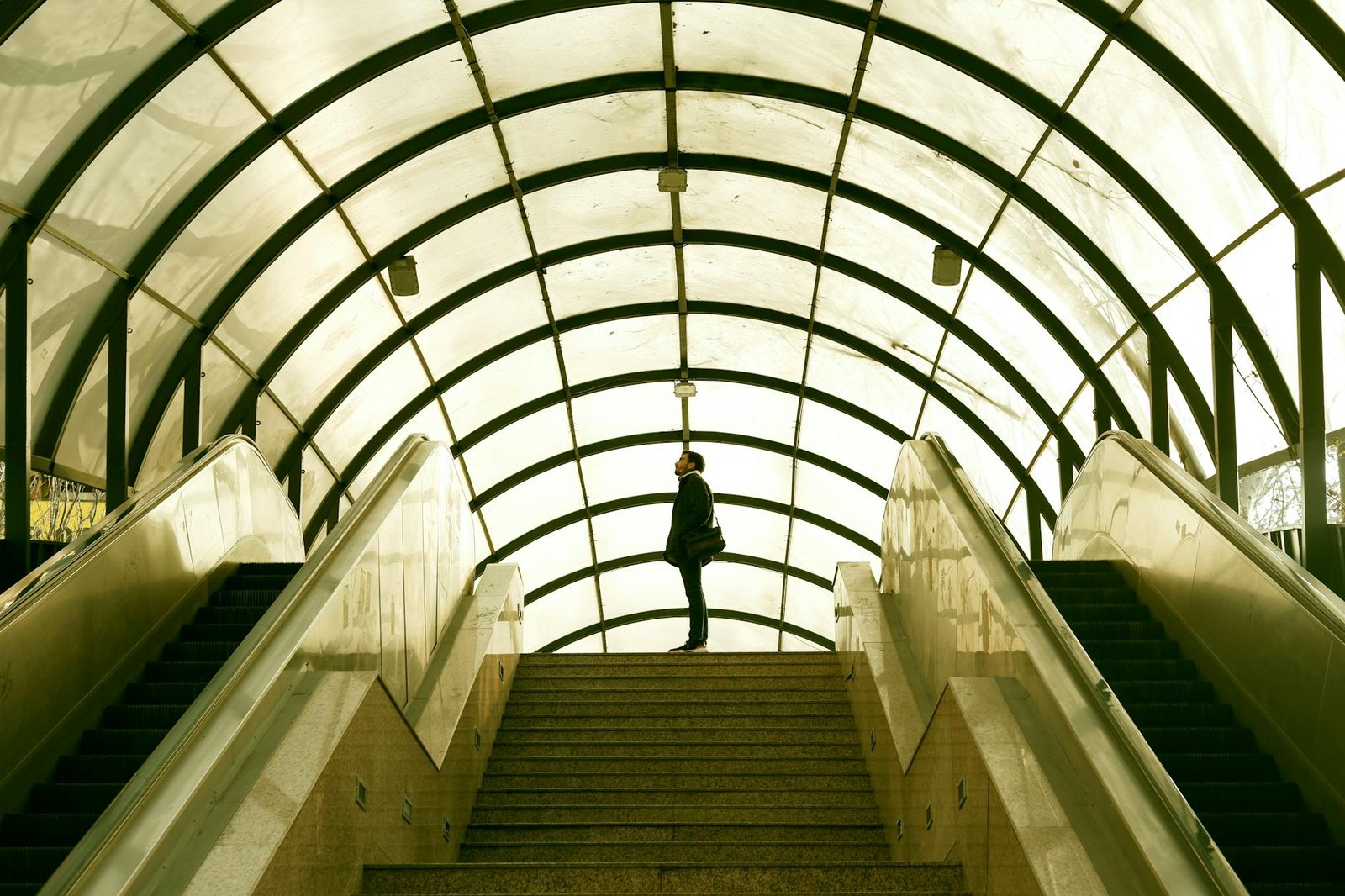 person standing at top of stairs in tunnel
