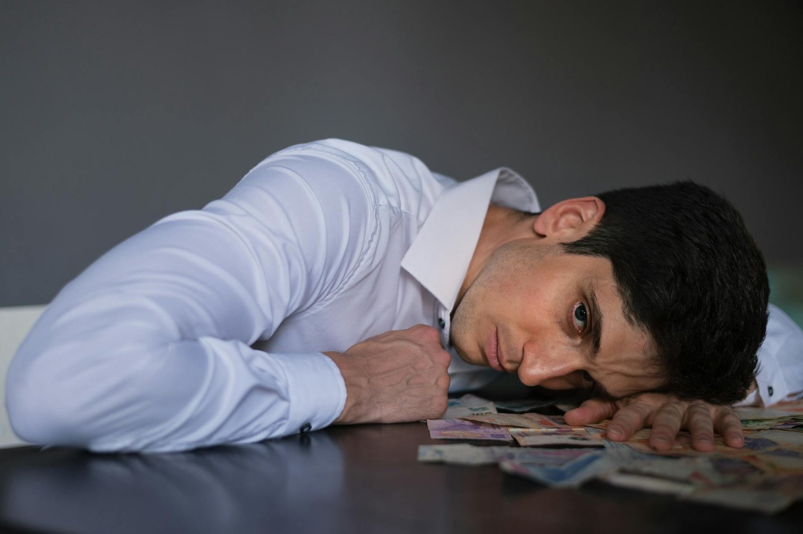 stressed businessman with money on table