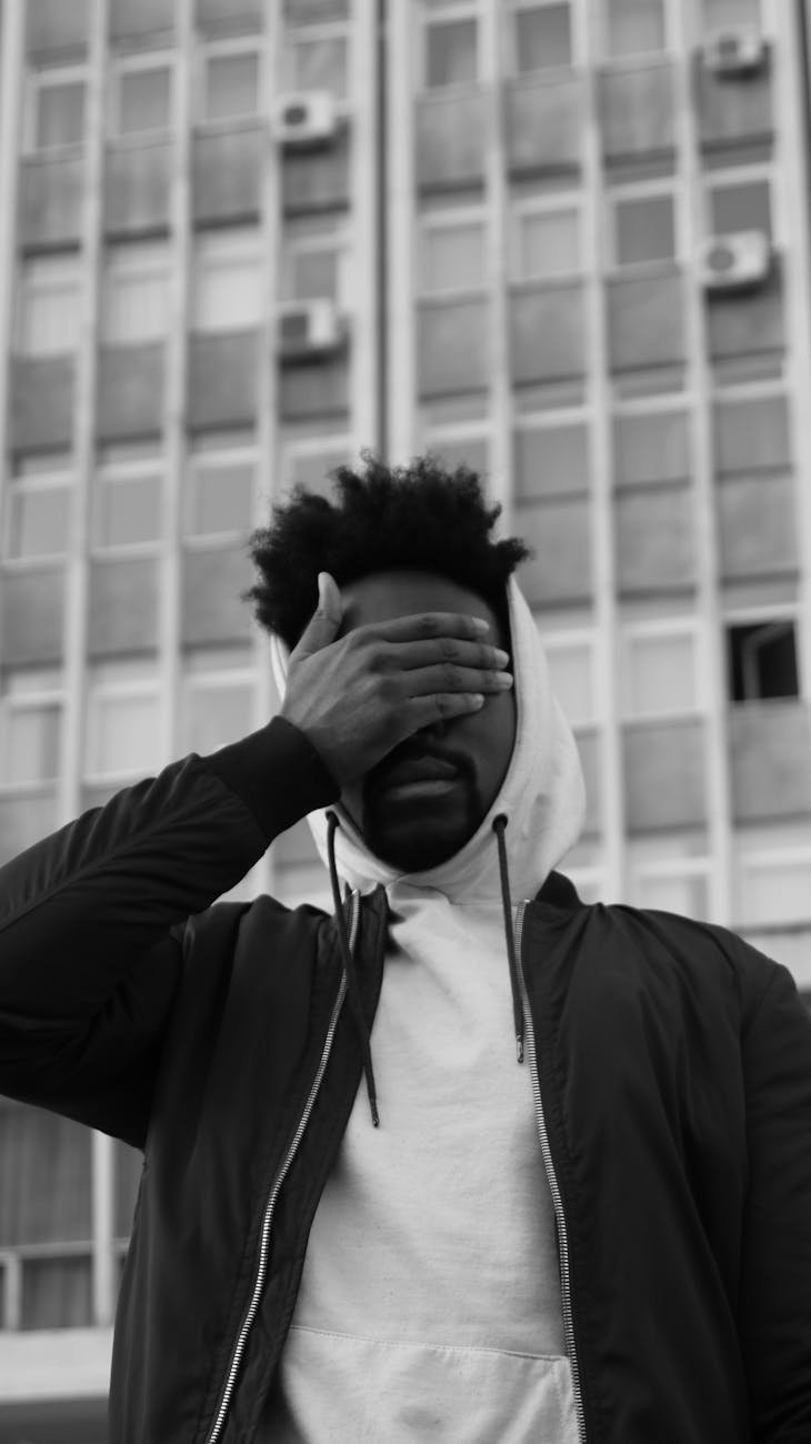 man covering his face with his hand